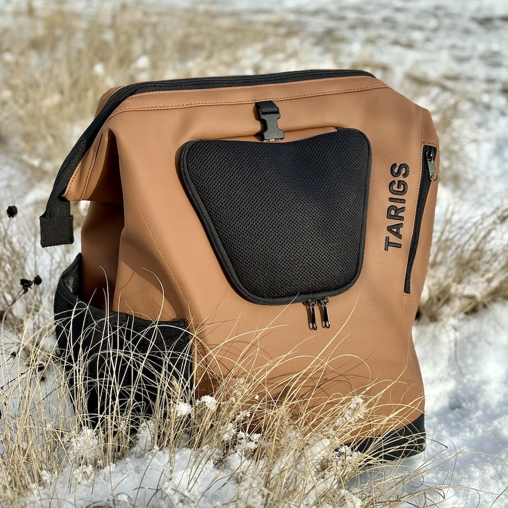 Der MountainRock Backpack - Brown (Vegan Leather) stehet im Schnee auf einer Düne.