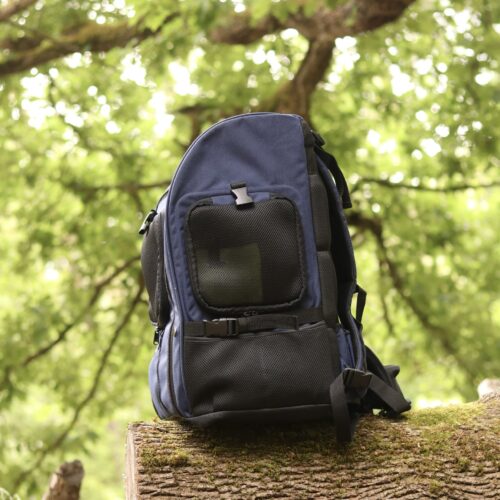 TARIGS Bulldog Backpack in Cobalt Blue frontally on a tree trunk in the forest